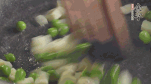 鍋中油7成熱時，入青豆、筍丁翻炒，然后加糯米飯加鹽均勻翻炒。