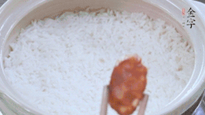 煮開后轉(zhuǎn)小火，當(dāng)米飯出現(xiàn)小孔時(shí)，鋪上金字麻辣香腸。