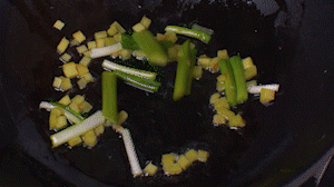 鍋中熱油，依次下姜粒、蔥段、蘆筍炒香。