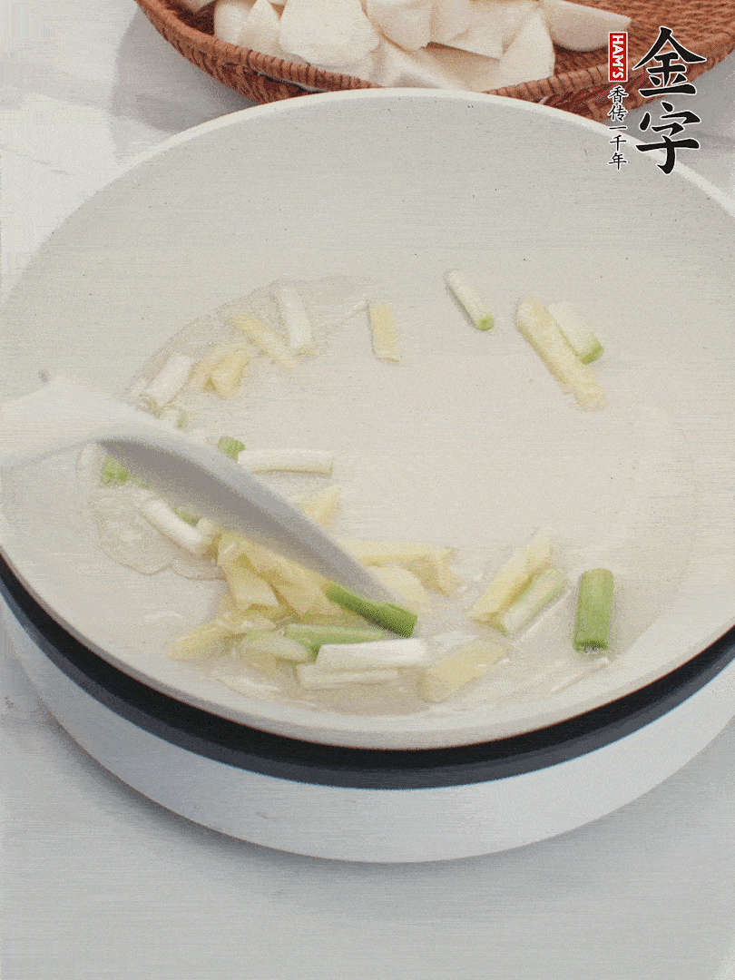 鍋中油五成熱，下蔥白、姜片爆香。