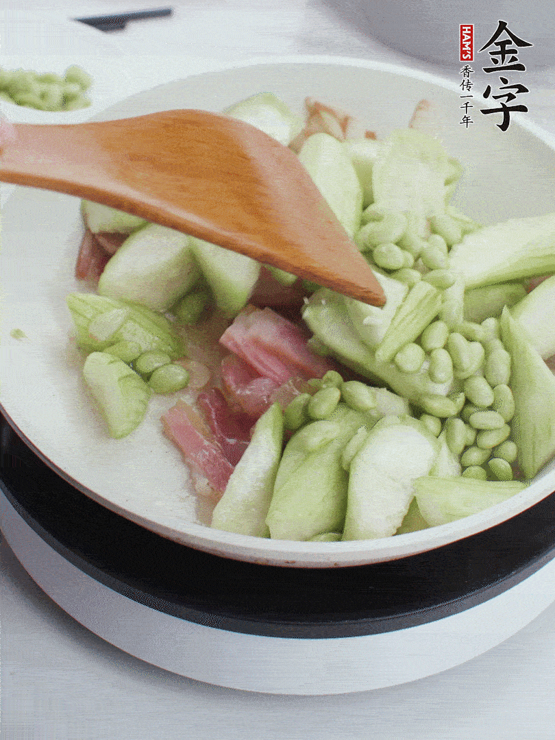 依次下絲瓜、青豆翻炒，炒至絲瓜打蔫縮小。