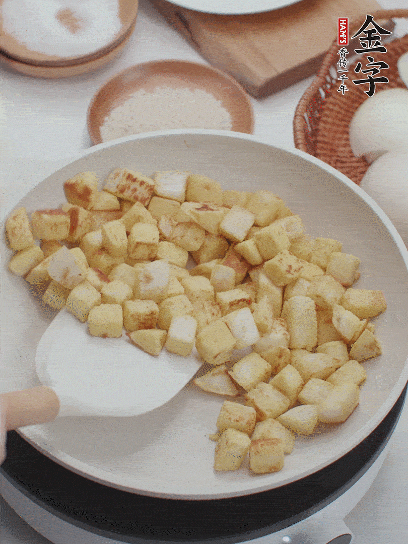 起鍋熱油，倒入饅頭丁，小火煎至蛋液凝固定型再翻面，饅頭丁部煎至金黃時盛起待用。