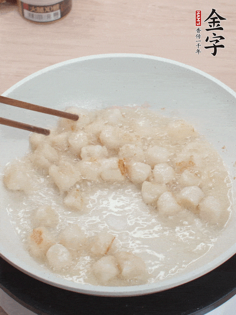 油溫4成熱，鮮貝蘸干淀粉下鍋煎，一面微黃后翻面。