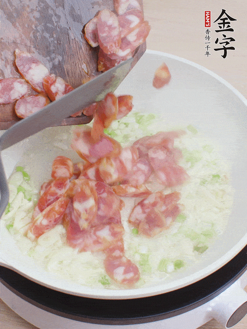 油5成熱，蒜末、蔥白爆香，下香腸炒出香味。