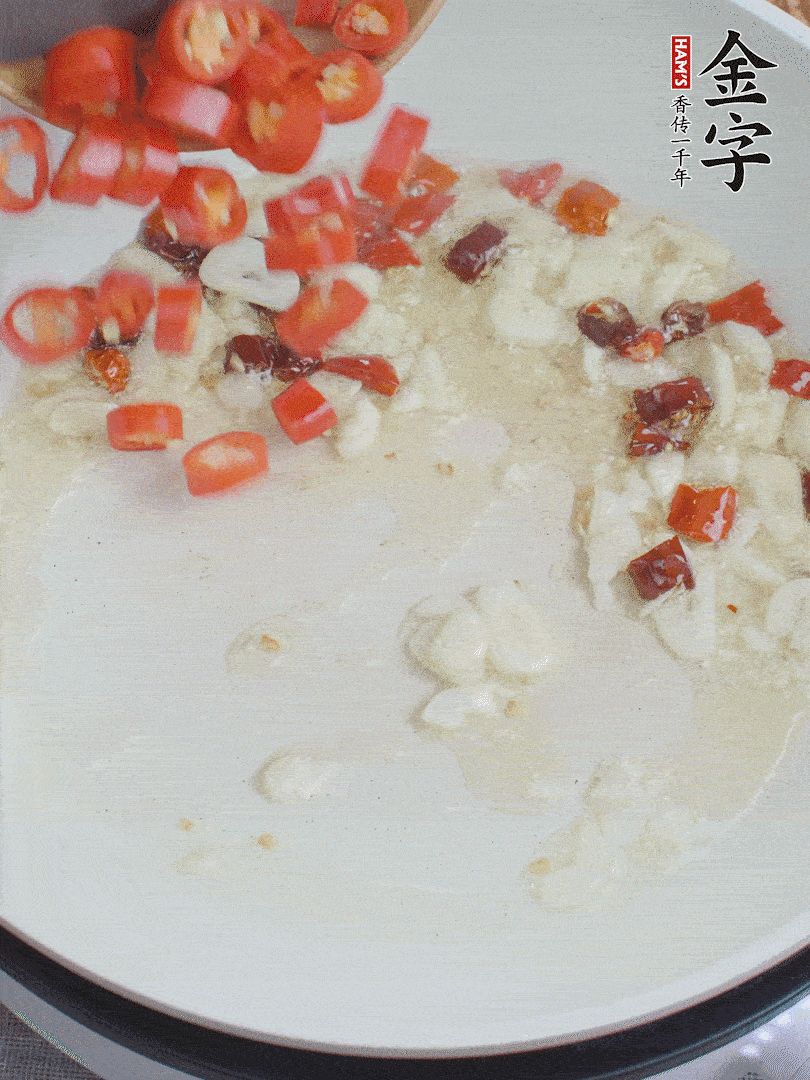 油6成熱，下蒜末、干紅辣椒煸炒，出香味后再放美人椒、香腸。