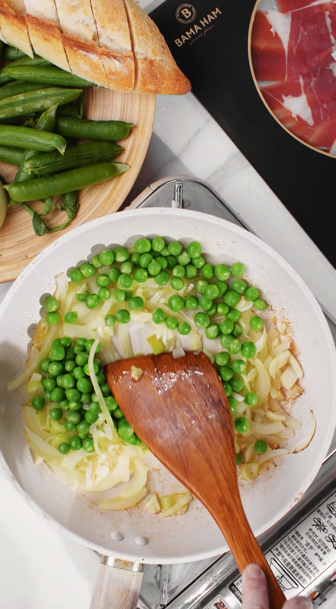 鍋中放入黃油融化，加入洋蔥絲、大蔥蔥白絲、蒜末翻炒變軟出香味。加入剛剛汆燙冰鎮(zhèn)后的豌豆，取出一點(diǎn)點(diǎn)待會擺盤裝飾用。加一點(diǎn)鹽 (和黑胡椒) 調(diào)味。
