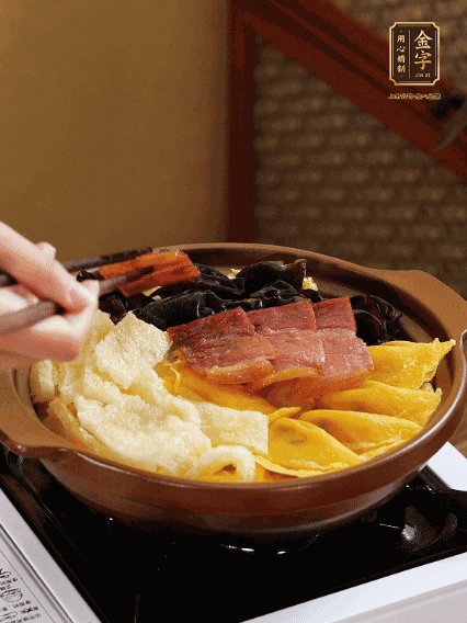 砂鍋底部鋪上娃娃菜，依次擺上肉皮、蛋餃、黑木耳、火腿